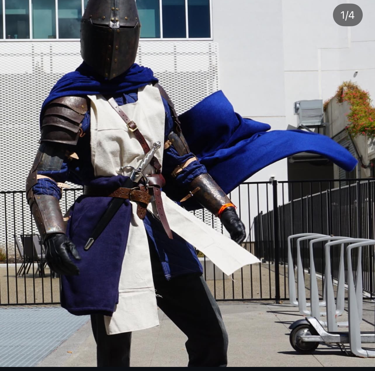 Blue and white Milanese armor outdoors holding a sword.