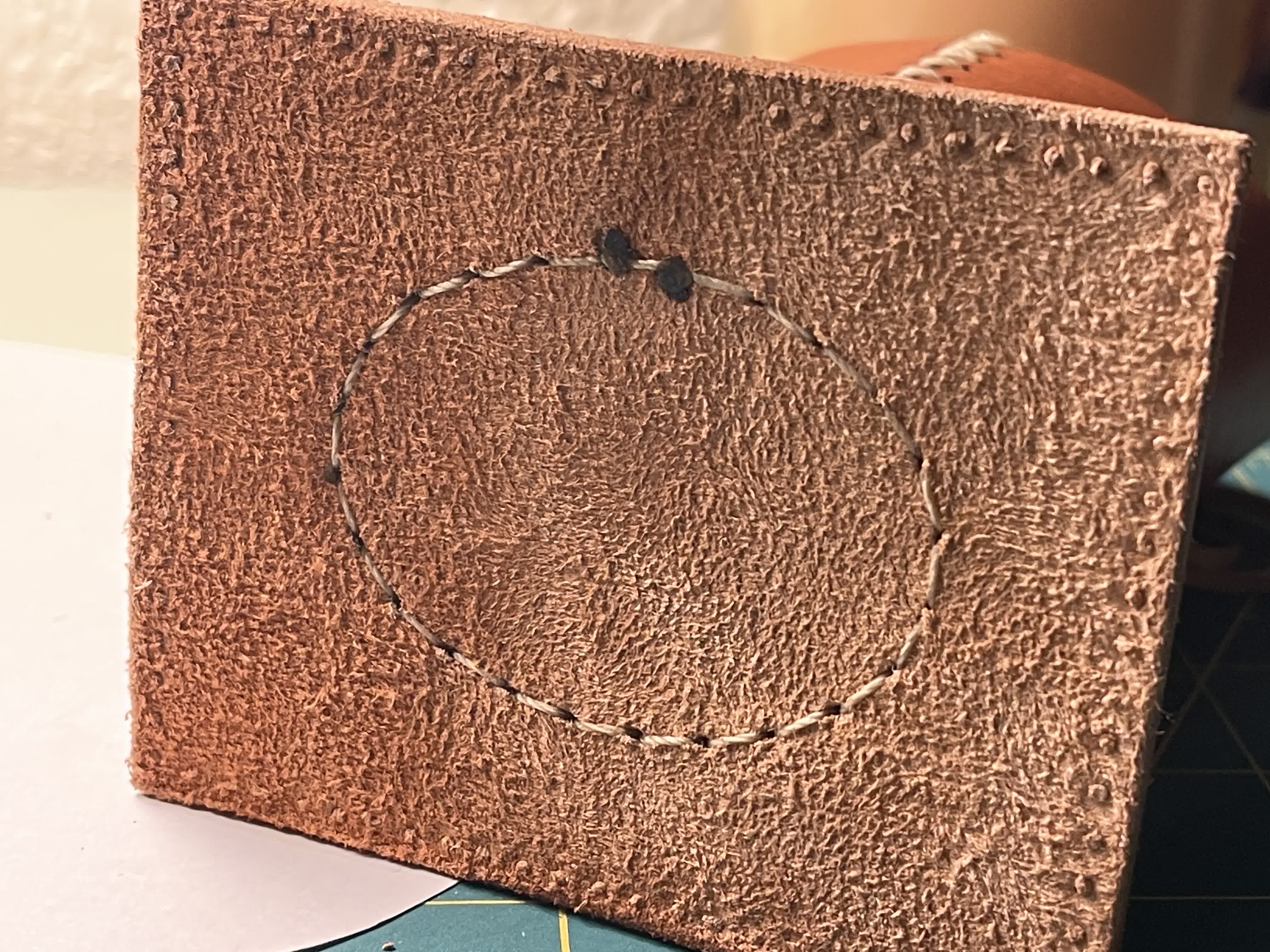 Side profile of the brown leather eyeglass holder on a work table.