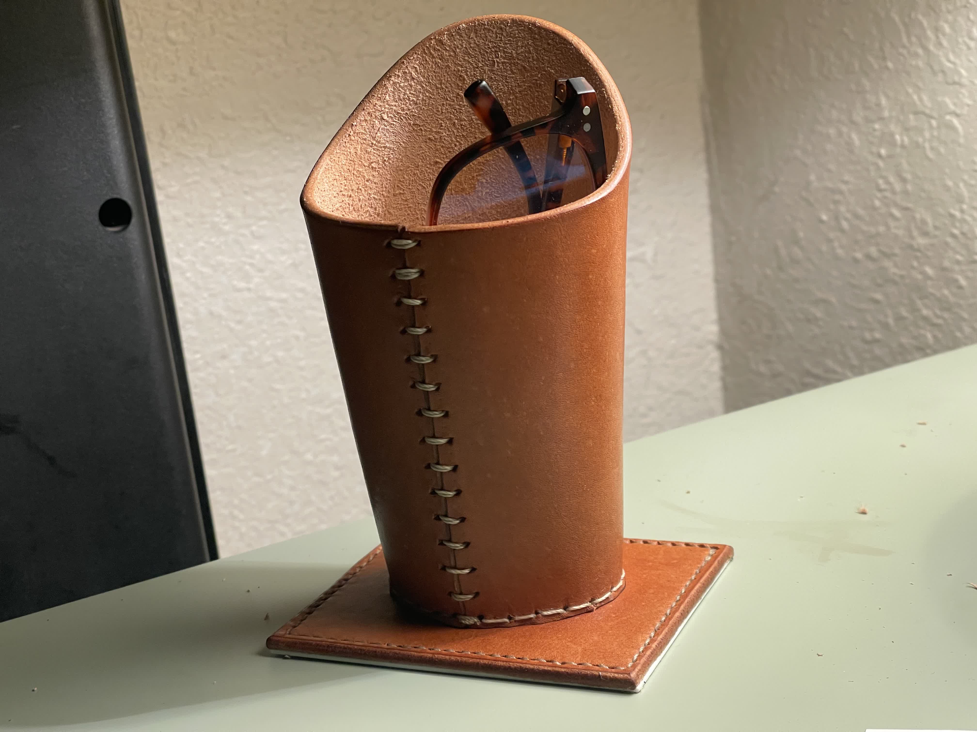 Front view of the leather eyeglass holder on a cutting mat.